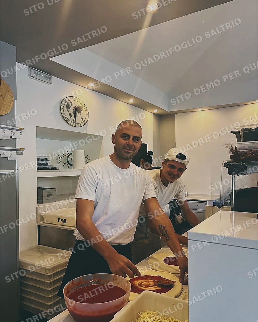 I pizzaioli di Quadrifoglio al banco mentre stendono il pomodoro